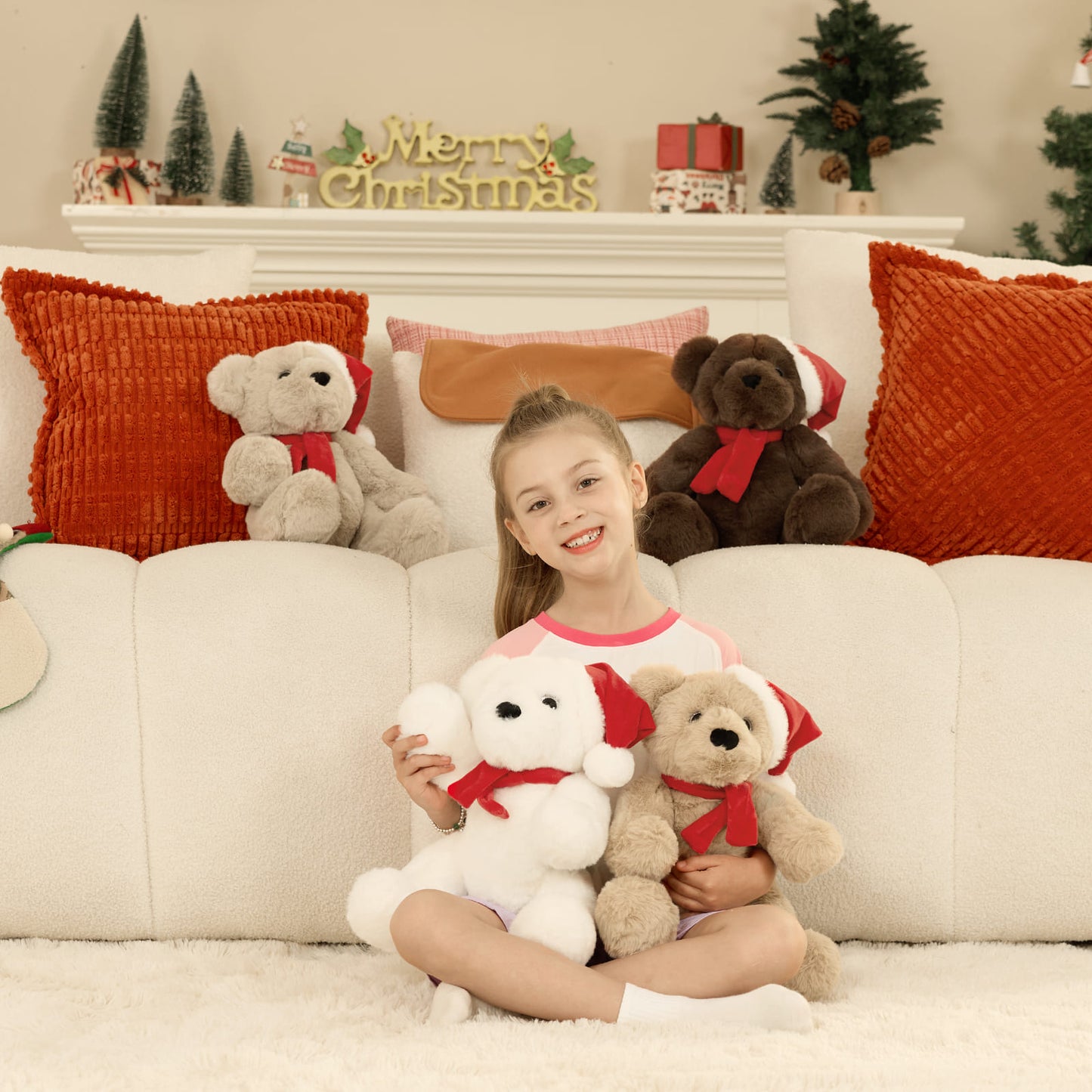 Young girl sitting on a couch with Christmas-themed teddy bears and decorations.
