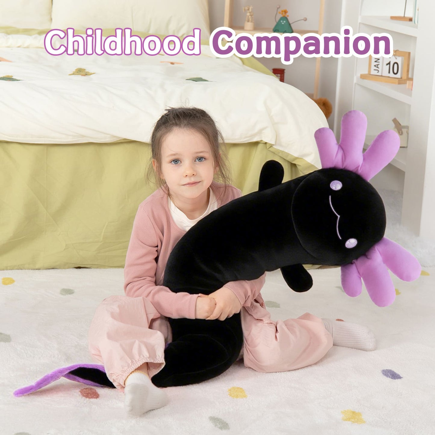 Child holding a large plush toy with a purple tail and black body, sitting on a bed.